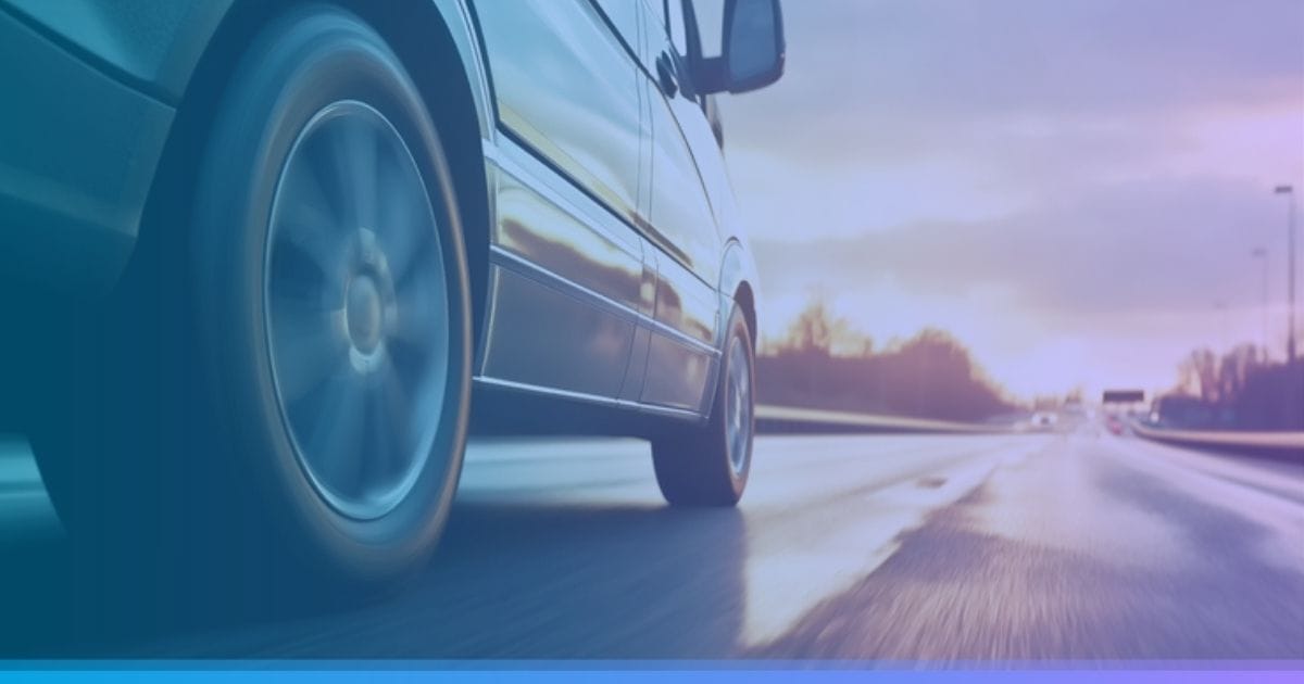 Car driving fast on a highway at sunset with blurred motion effect and cloudy sky in the background