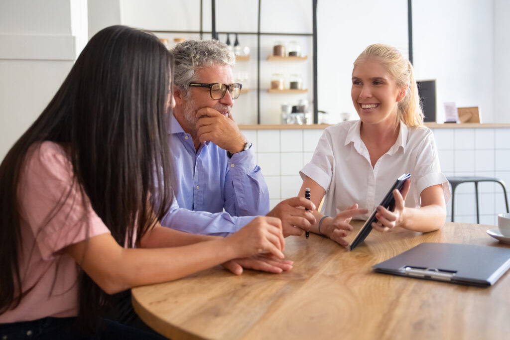 cheerful-female-manager-young-mature-customers-watching-discussing-presentation-tablet-smiling-talking