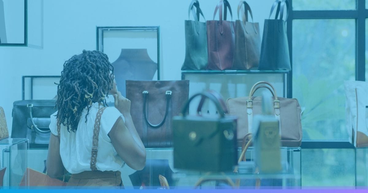 Woman browsing leather handbags on display in a store.