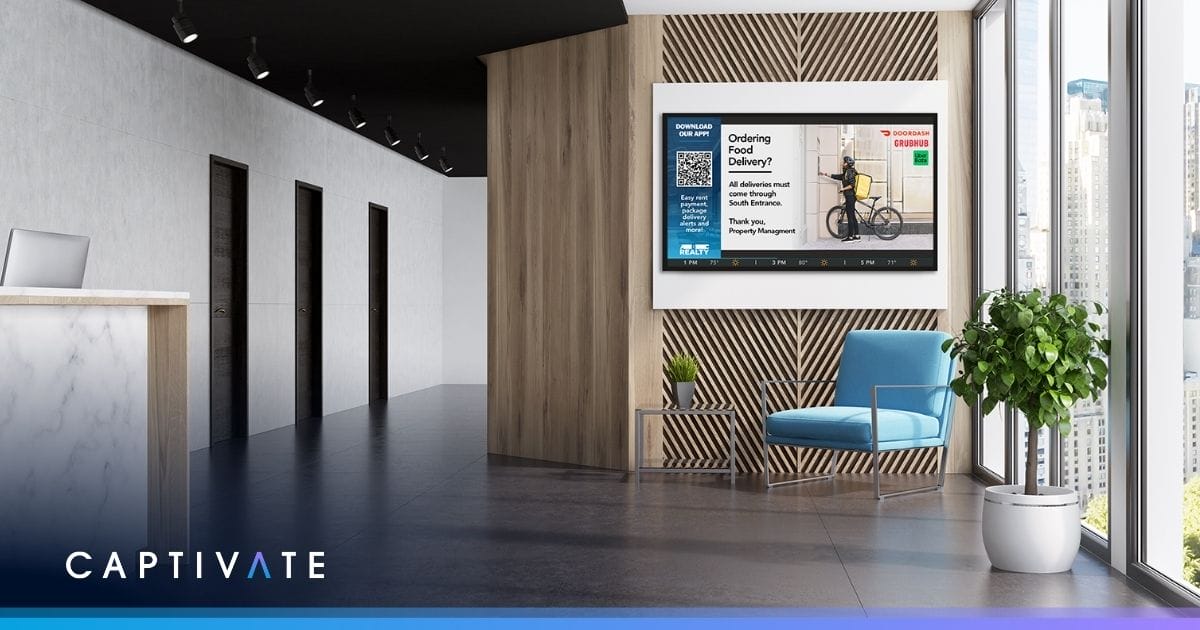 Modern office lobby with digital display, blue chair, and potted plant near window showcasing city view.