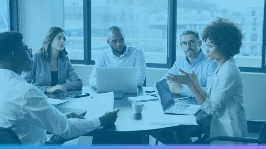 People having a meeting in a modern office with laptops and documents on the table.