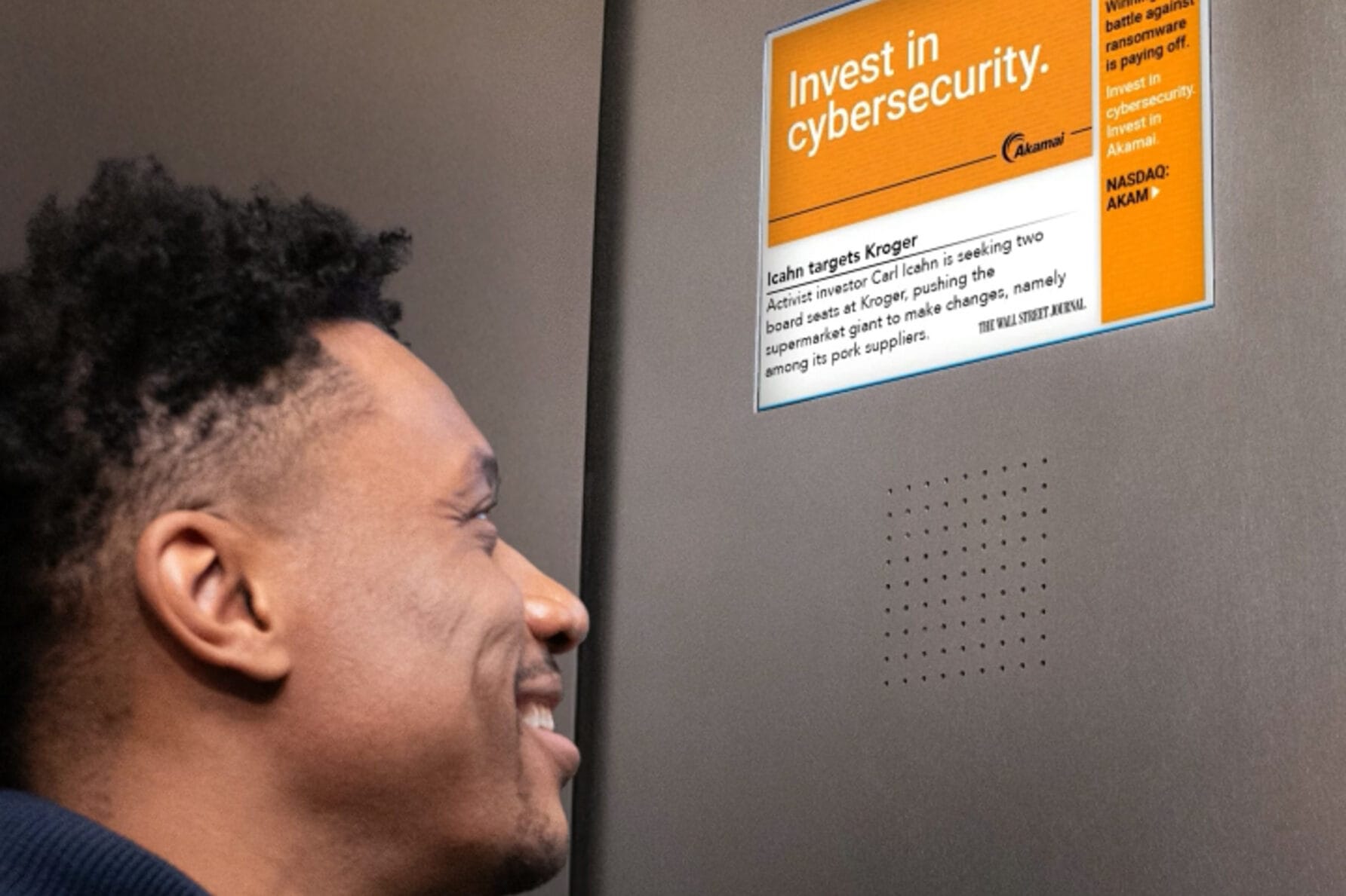 Man smiling at a bulletin board with a poster about crypto security.