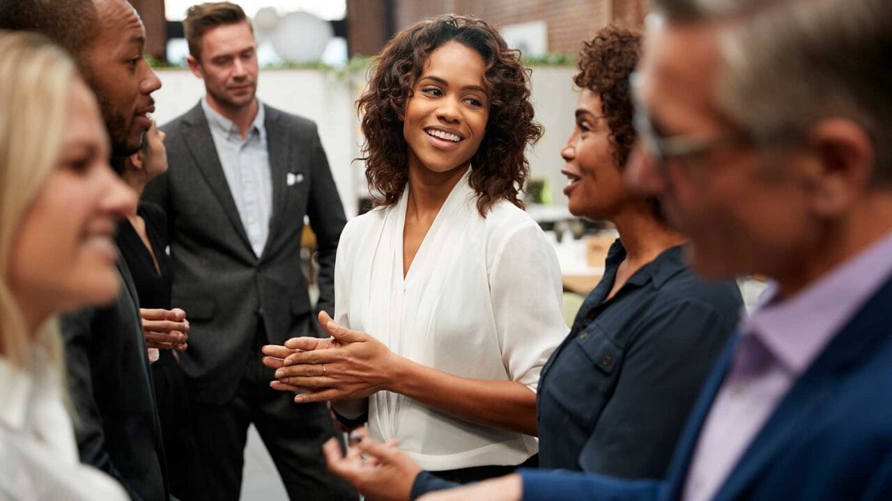 Group of diverse professionals having a lively discussion in an office setting.