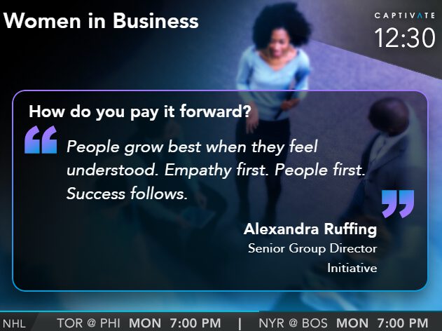 TV screen showing a quote about empathy and success in business, with a person walking in the background.