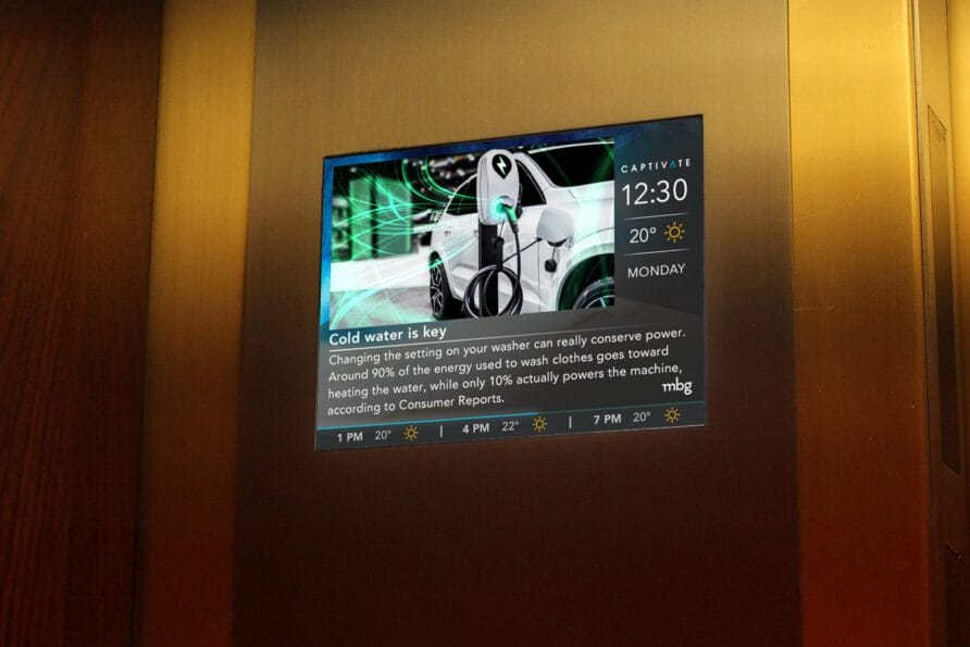 Digital screen in an elevator displaying news and weather updates with a background image of a white vehicle and urban elements.