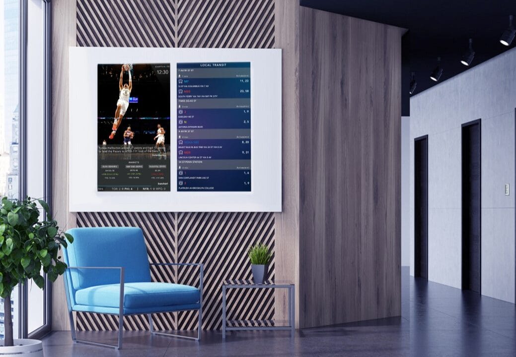 Modern office lounge with a digital screen displaying basketball game stats and a blue chair with a small table.