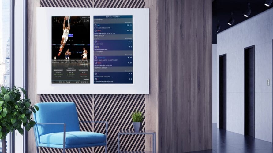 Modern office lounge with a digital screen displaying basketball game stats and a blue chair with a small table.