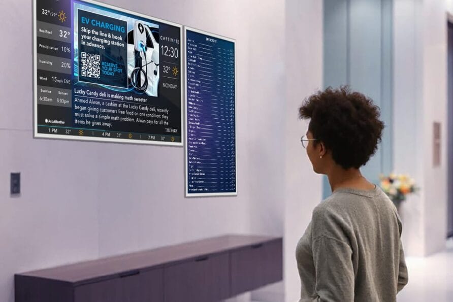 Person looking at a digital display on a wall in a modern, sleek room with informational graphics and text.