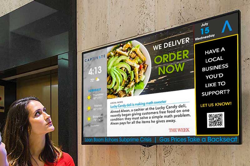 Woman looking at digital screen displaying weather, news headline, and local business advertisement.