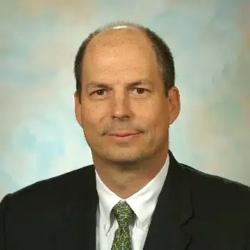 Portrait of a man in a suit and tie against a neutral background.