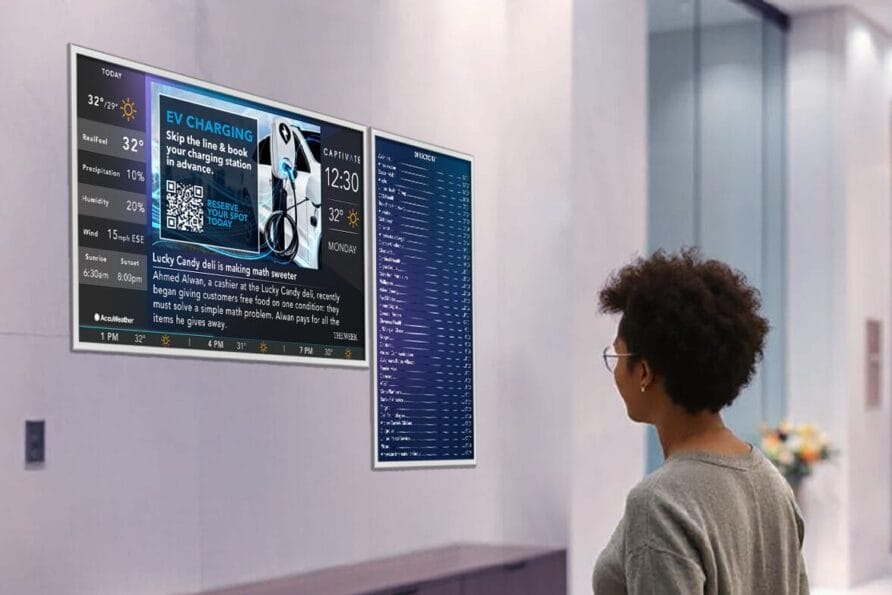 Person reading a train schedule on a wall-mounted display board in a modern station setting.