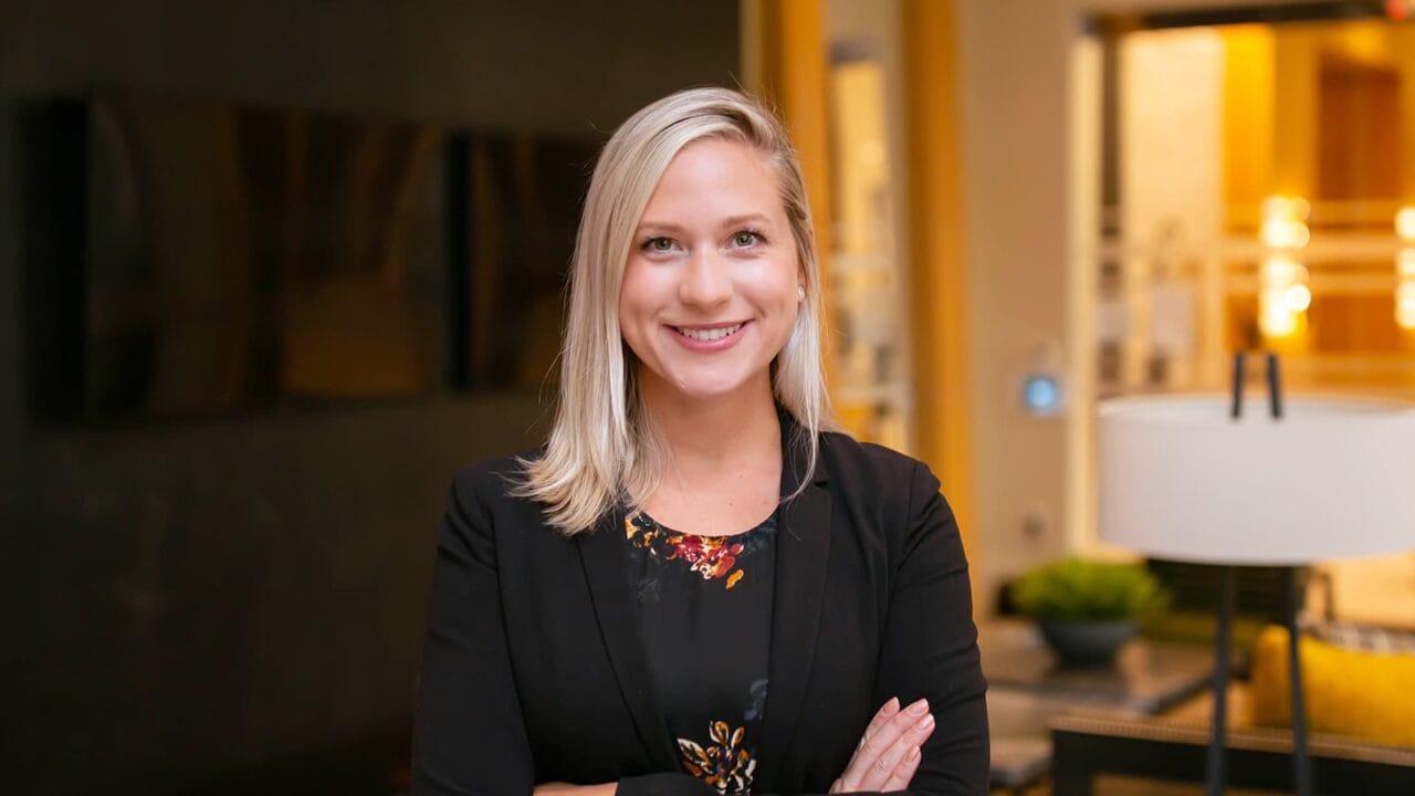 Person smiling in a professional setting with blurred background and modern decor.