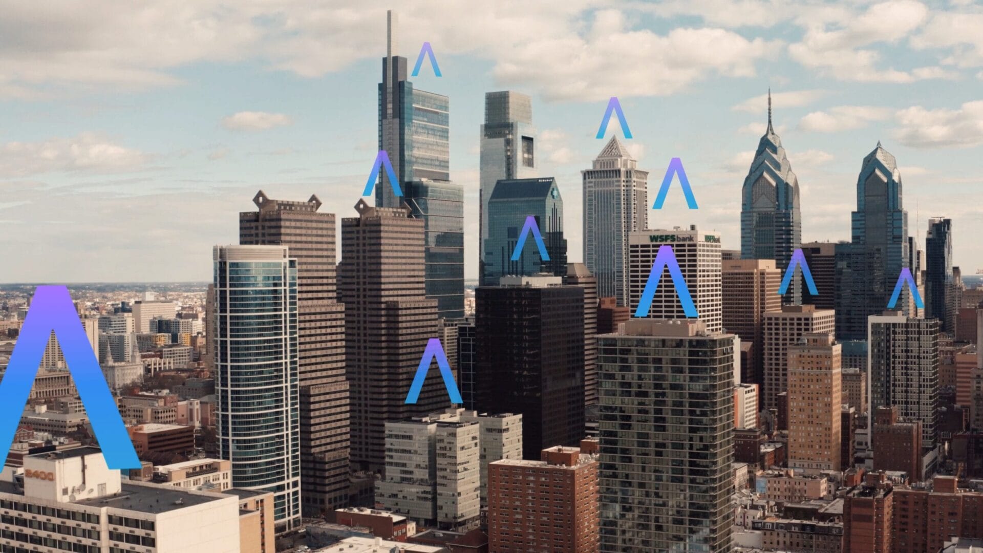 City skyline with blue arrows above several skyscrapers under a cloudy sky.