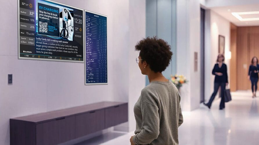 Person in a modern lobby observing digital displays with information and schedules on the wall.
