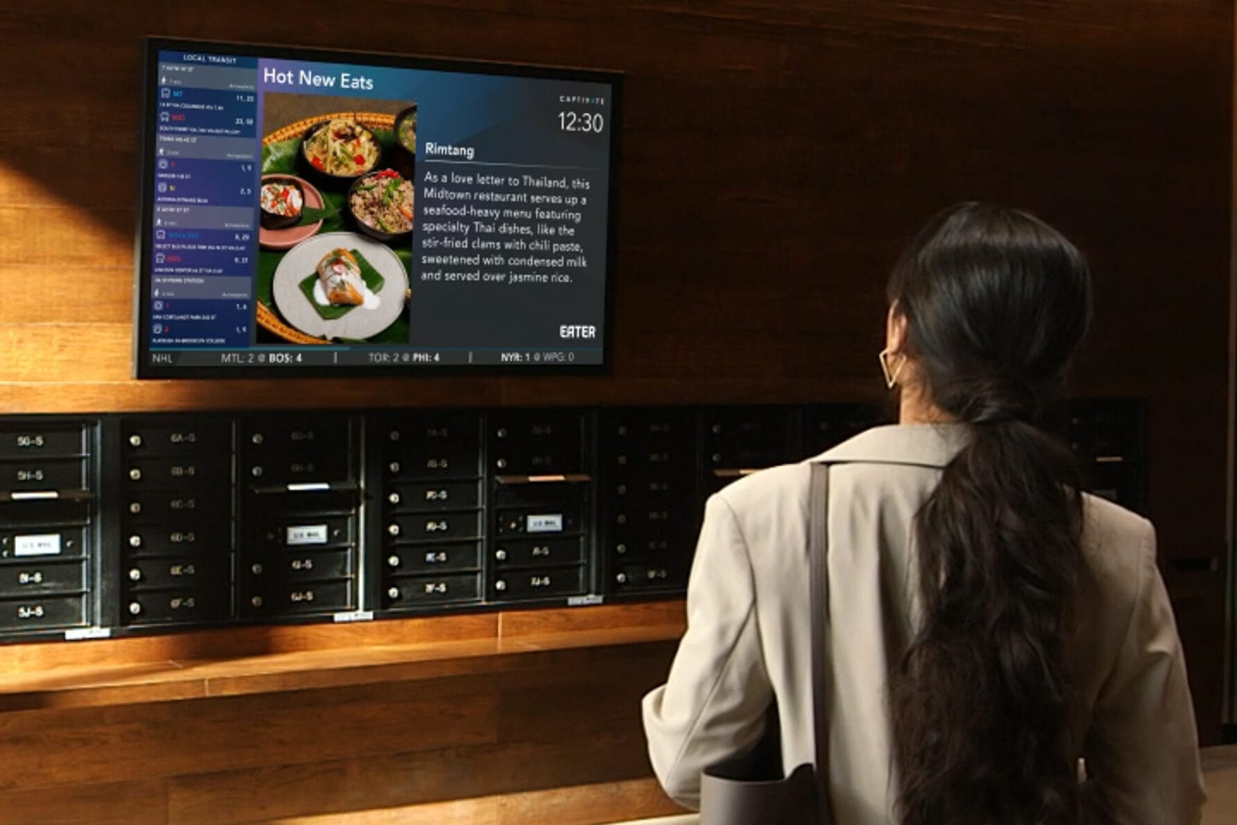 Person viewing a digital menu board displaying food options in a contemporary setting.