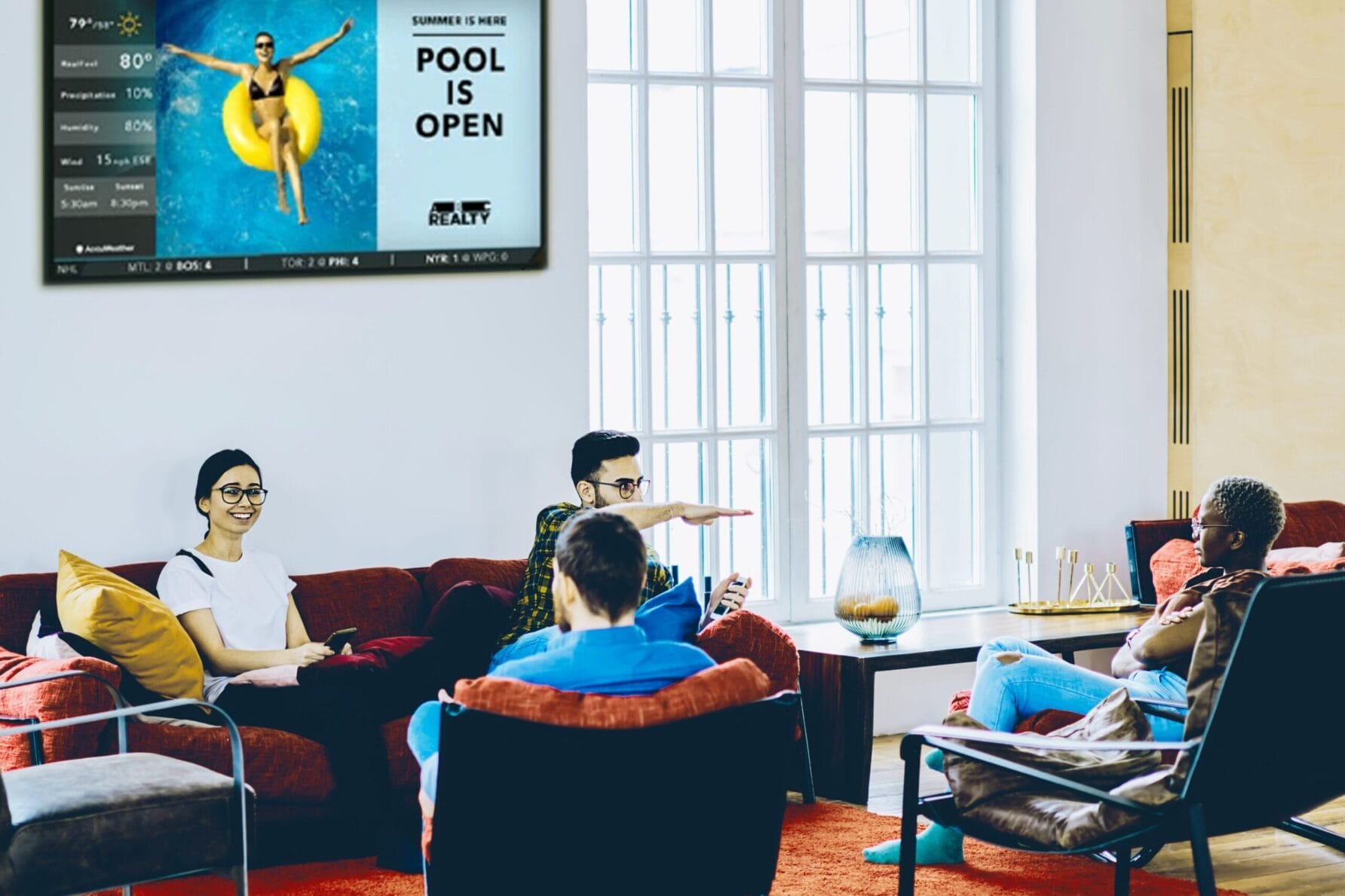 People sitting on couches in a modern room with a poster of a bee on the wall.