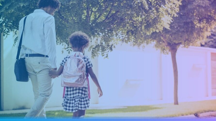 Adult and child holding hands, walking on a sidewalk with trees, child wearing a backpack.